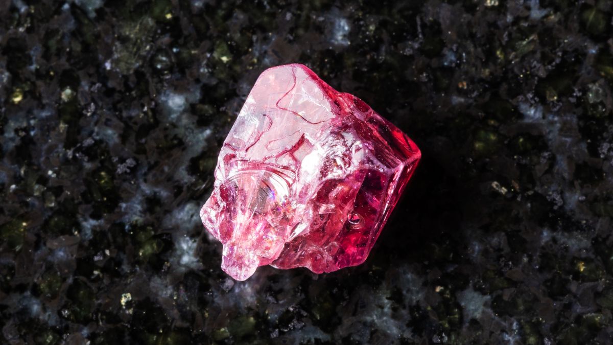 Egy fekete háttéren elhelyezett fekete spinell ásvány, amely erőteljes védelmet nyújt és energiát tölt fel.