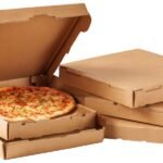 Karton pizzadobozok, egy friss pizzával a nyitott dobozban.