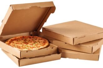 Karton pizzadobozok, egy friss pizzával a nyitott dobozban.